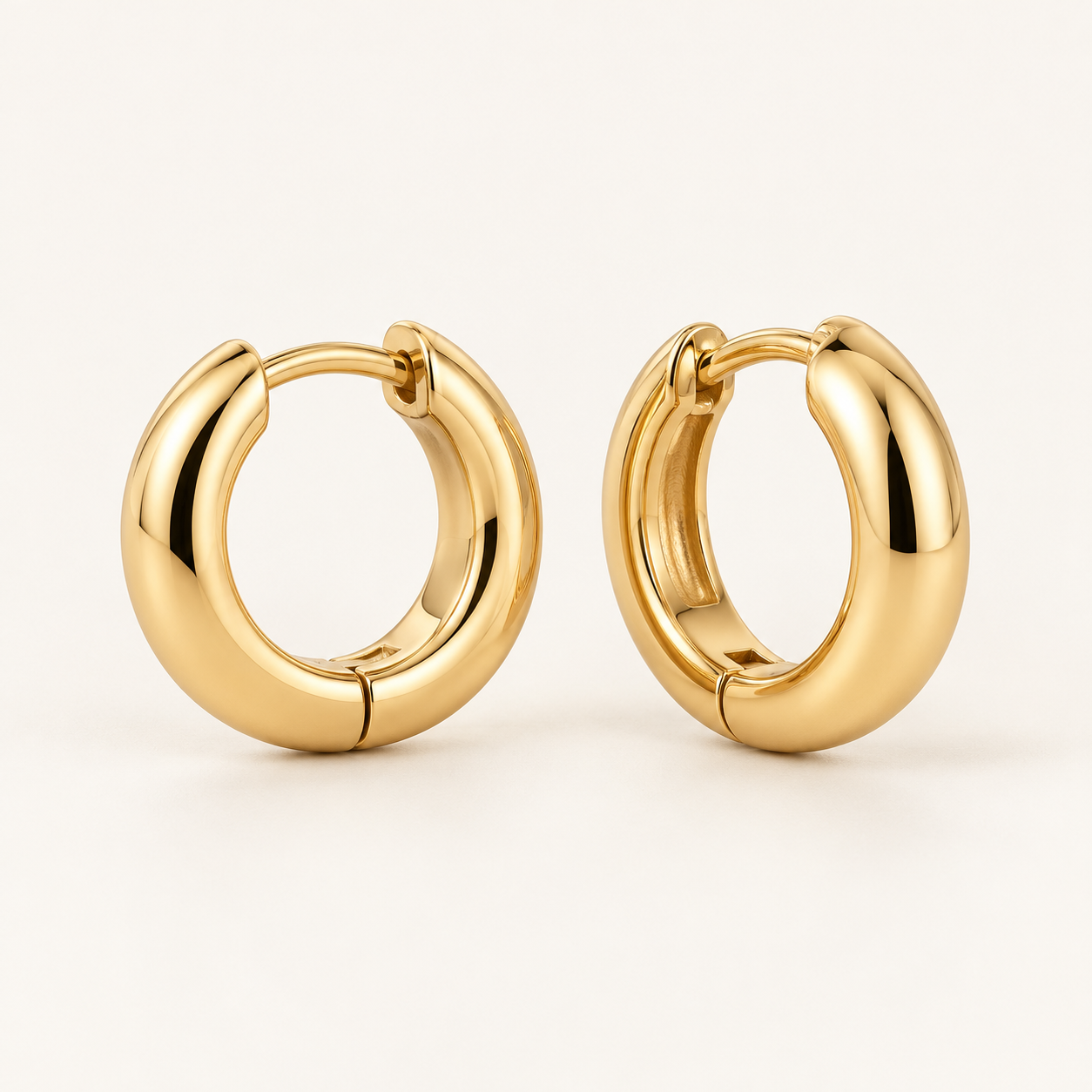 Lumière Huggie Earrings on an ivory background